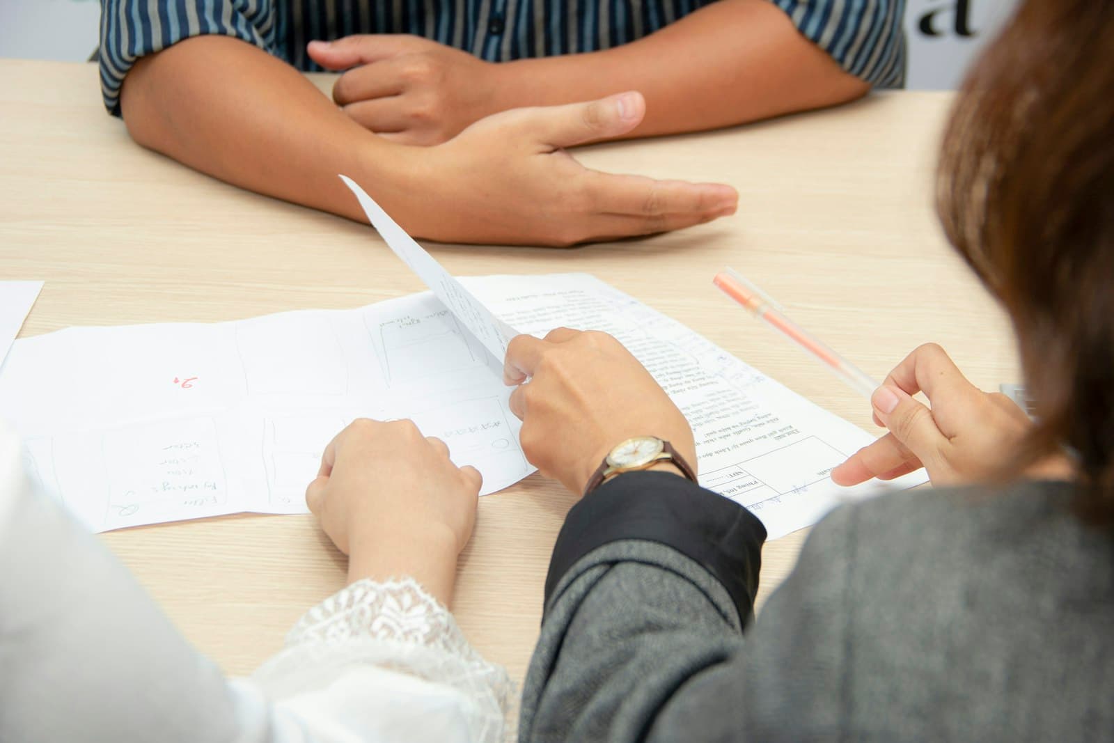 Hiring team reviewing a candidate’s papers across a table