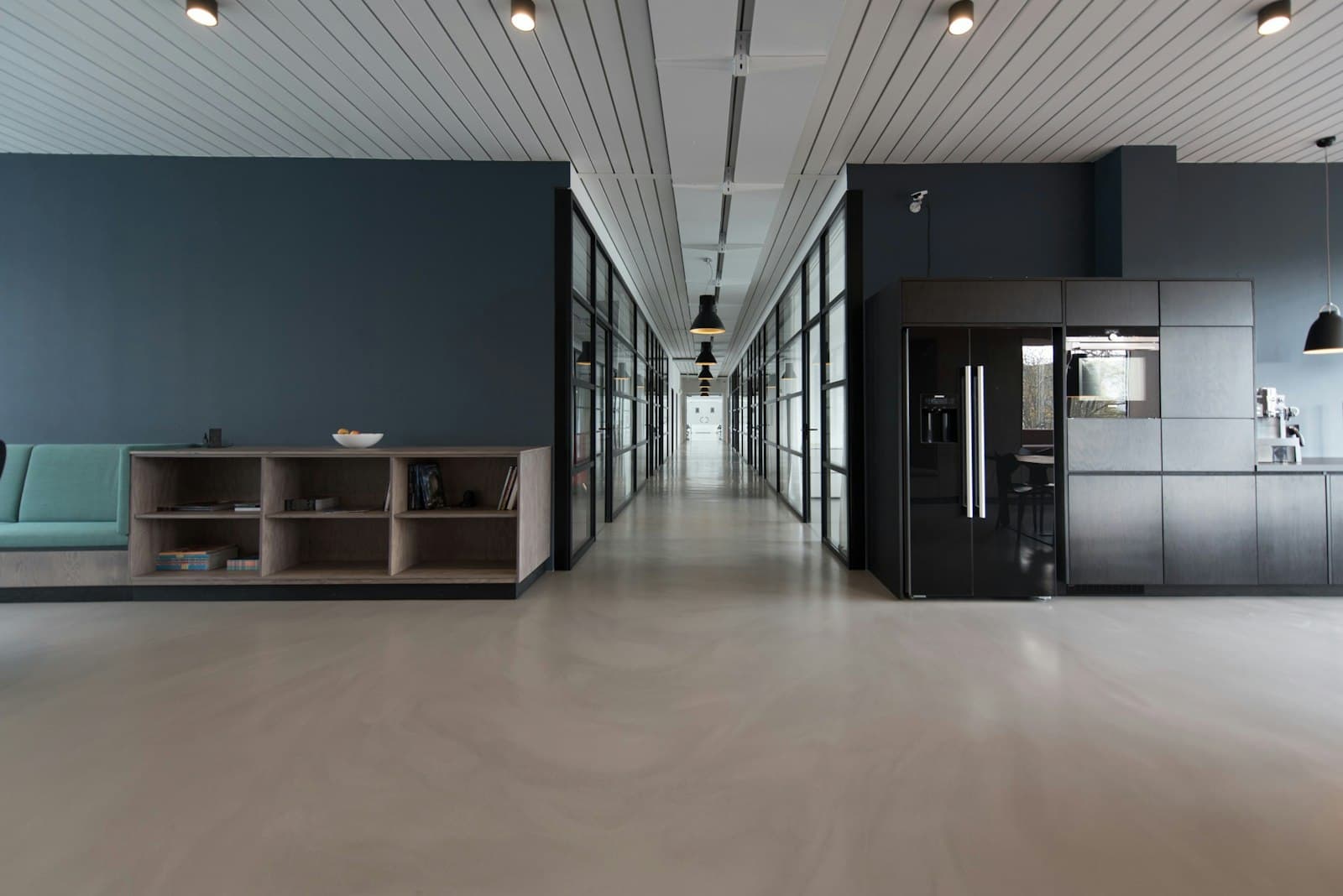 An empty office hallway with glass meeting rooms