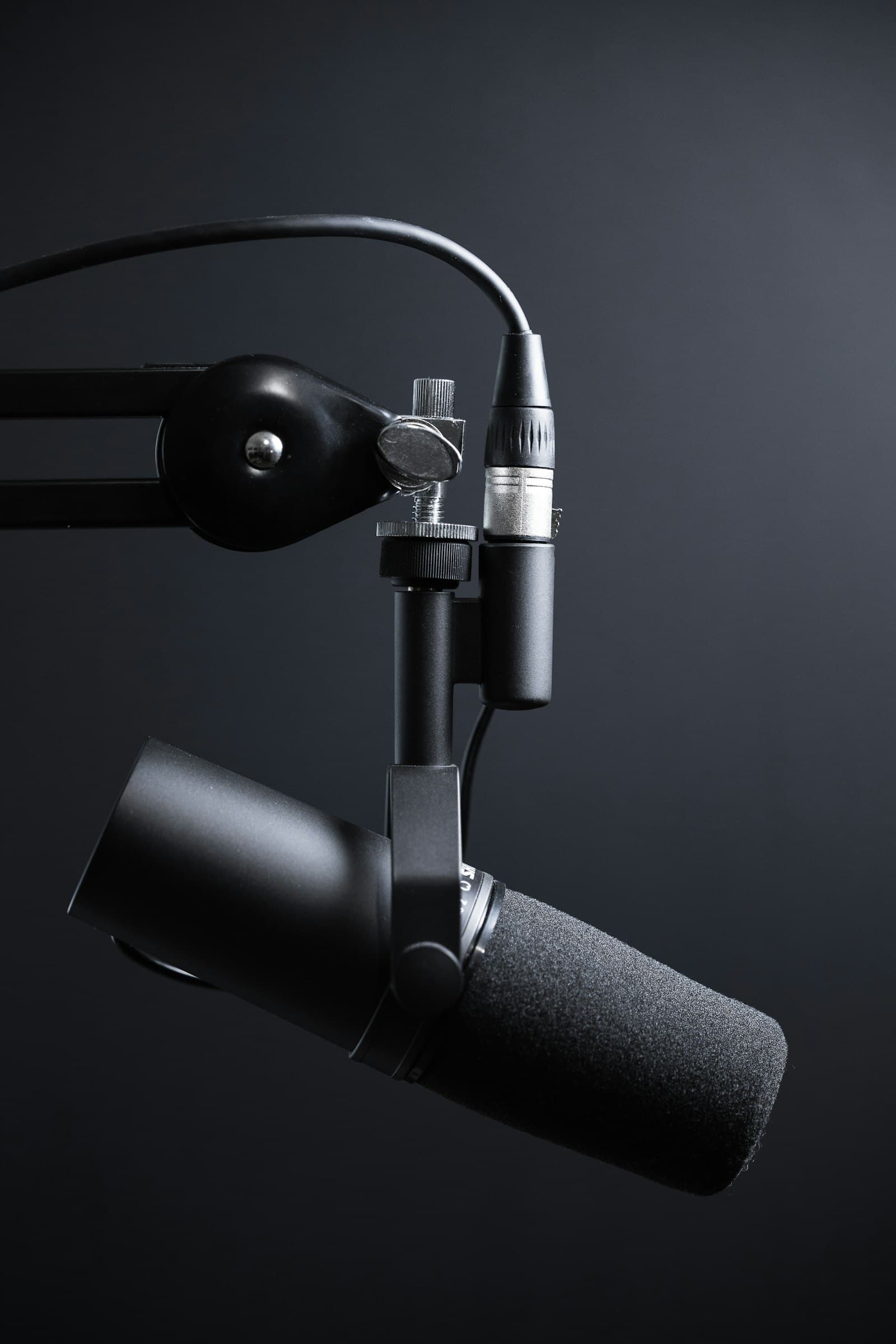 A broadcast microphone on a boom arm